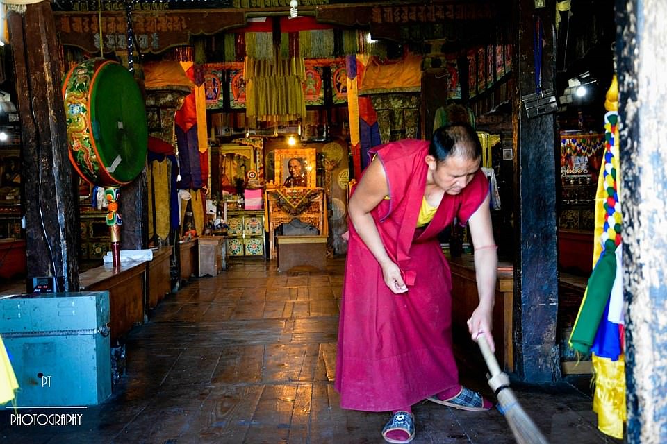 A monk sweeping the sacred prayer hall